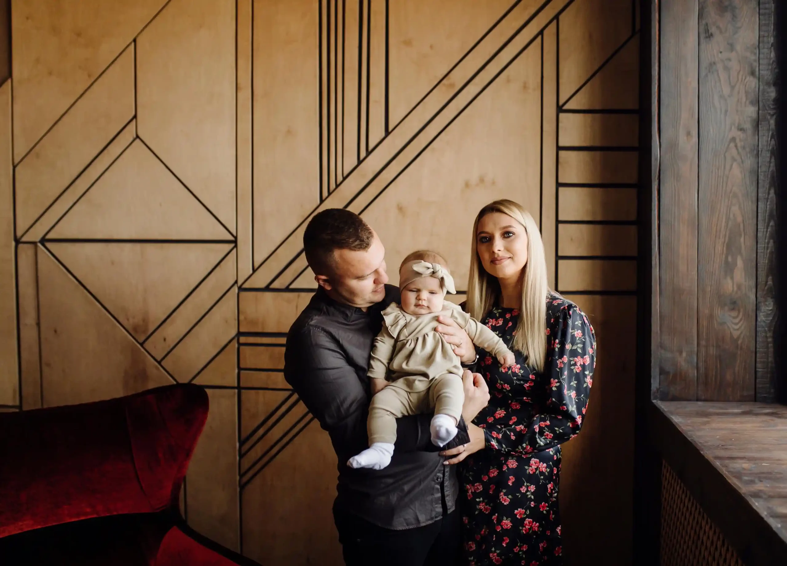 Parents posing with baby during professional family photography session in Cambridge UK