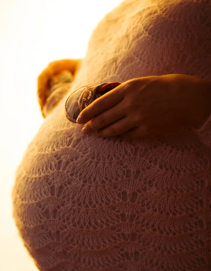 evening-sun-illuminates-pregnant-belly-shoes-it