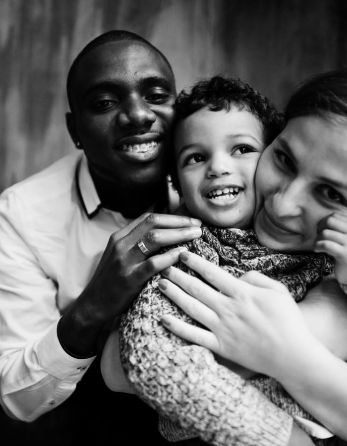 Happy multiethnic family with boy kid spend time at restaurant. Relationships of african man and white european woman.